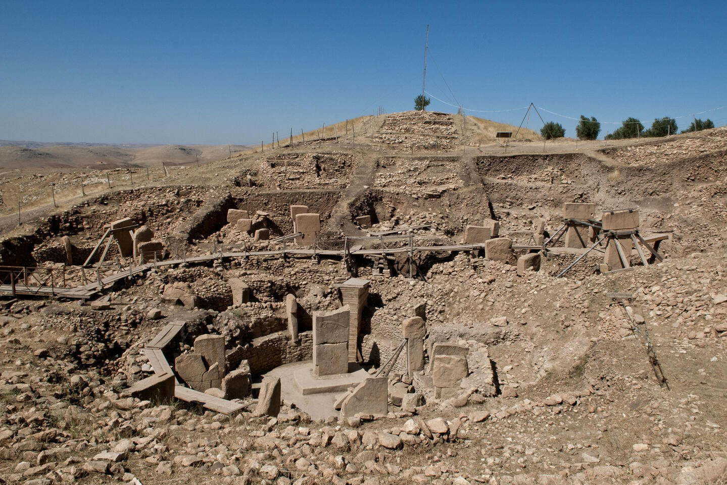 Göbekli Tepe, Şanlıurfa · Teomancimit · CC BY-SA 3.0 · cropped and resized Excavated stone enclosures and T-shaped pillars at Göbekli Tepe in Türkiye.